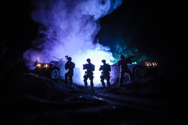 Savaş Konsepti. Savaş sahnesi sisli gökyüzü arka planında geceleri Bulutlu Skyline 'ın altında siluetlerle savaşmak. Askerlerin sanat eserleriyle donatılmış askeri araç. Seçici odak