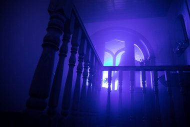 Terk edilmiş eski korkunç malikanenin içinde. Korku hayaleti silueti bodruma inen şatonun merdivenlerinde duruyor. Korku Cadılar Bayramı konsepti