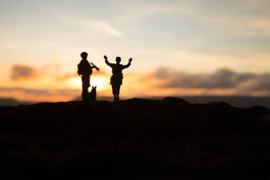 Savaş sahnesi. Askeri savaş sis gökyüzü arka plan üzerinde mücadele sahne siluetleri. Bir Alman askeri silah teslim ortaya çıkar. Plastik oyuncak askerler silahlı düşman askeri esir alarak. Sanat