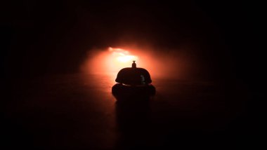 Ahşap masadaki servis zilini arıyorum. Arka planda tonlu ışıklar var. Otel resepsiyon zili, servis zili masada, seçici odak