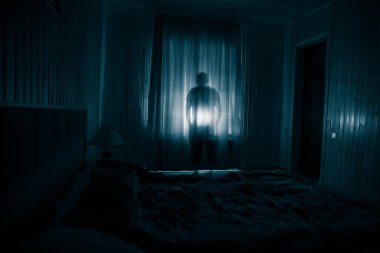 Geceleri yatak odasında perdesi olan korkunç bir siluet. Korku sahnesi. Cadılar Bayramı konsepti Bulanık hayalet silueti