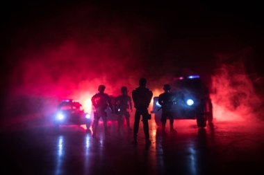 Polisle Corona virüsü konsepti. Corona virüsünü önlemek için tedbir amaçlı önlemler için evde kal. Çevik kuvvet polisi hazır olmak için işaret verdi. Karanlık arka planda ışıklarla tüttürmek. Seçici odak