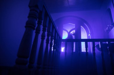 Terk edilmiş eski korkunç malikanenin içinde. Korku hayaleti silueti bodruma inen şatonun merdivenlerinde duruyor. Korku Cadılar Bayramı konsepti