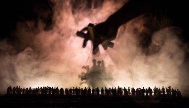 Koronavirüsle yaratıcı manipülasyon kavramı. Kalabalık büyük Corona virüsü minyatürüne bakıyor. Covid19 minyatürünü kontrol eden el sisli bir arka planda sicimler taşıyor. Seçici odak