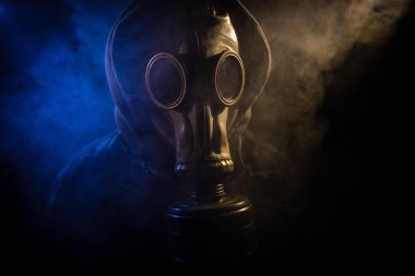 Çevre felaketi. Karanlık bir arka planda gaz maskeli kıyamet sonrası hayatta kalan biri. Gaz maskesi takan bir adamın dramatik portresi. Radyasyon koruması demek. Seçici odak