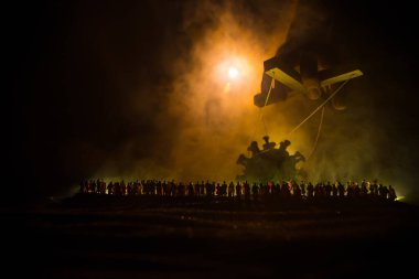 Koronavirüsle yaratıcı manipülasyon kavramı. Kalabalık büyük Corona virüsü minyatürüne bakıyor. Covid19 minyatürünü kontrol eden el sisli bir arka planda sicimler taşıyor. Seçici odak
