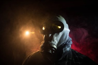 Çevre felaketi. Karanlık bir arka planda gaz maskeli kıyamet sonrası hayatta kalan biri. Gaz maskesi takan bir adamın dramatik portresi. Radyasyon koruması demek. Seçici odak