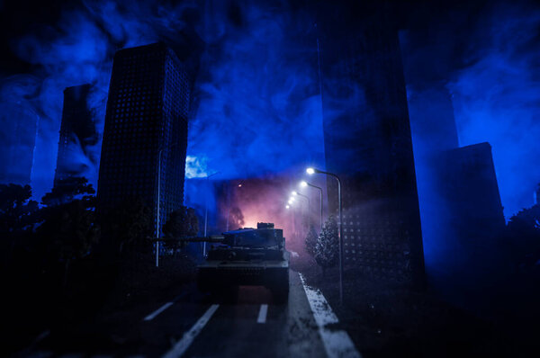 Empty street of burnt up city, flames on the ground and blasts with smoke in the distance. Apocalyptic view of city downtown as disaster film poster concept. Night scene. City destroyed by war.