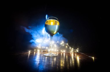 Ahşap masada şarap kadehi ve arka planda güzel renkli ışıklar. Karanlık arka planda şarap kadehleri. Seçici odaklanma. Kulüp içki konsepti