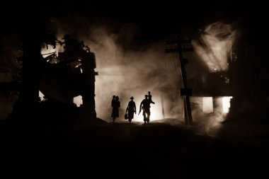 Mülteciler ve tutsaklar yıkılmış şehirde yürüyorlar. Savaş konseptinin berbat yüzü. Işık ve sisli yaratıcı sanat masası dekorasyonu. Seçici odak.