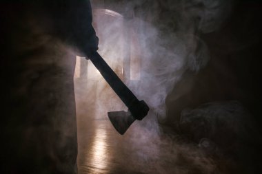 Geceleri arka planda duman olan ürkütücü siluet kız. Yaşlı baltayı tutan korkunç kadın. Seçici odak