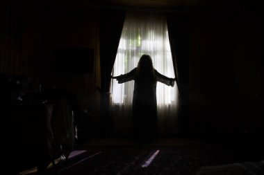 Geceleri yatak odasında perdesi olan korkunç bir siluet. Korku sahnesi. Cadılar Bayramı konsepti Bulanık hayalet silueti
