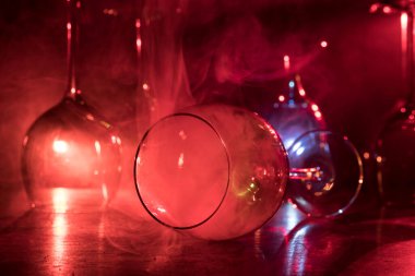 Ahşap masada şarap kadehi ve arka planda güzel renkli ışıklar. Karanlık arka planda şarap kadehleri. Seçici odaklanma. Kulüp içki konsepti