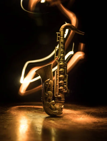 音楽の概念 サクソフォンジャズ楽器 霧の背景にカラフルなトーンの光とアルトゴールドサックスミニチュア 低光の中でサクソフォンの楽器 選択的焦点 — ストック写真
