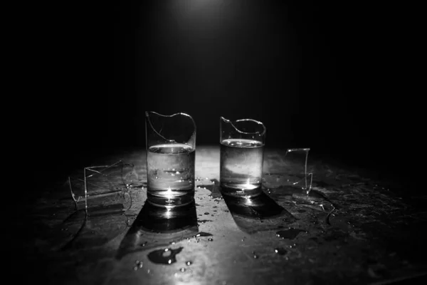 飲み物 壊れたガラスの概念 濃いトーンの背景に霧と木製のテーブルの上に壊れた眼鏡 選択的焦点 — ストック写真
