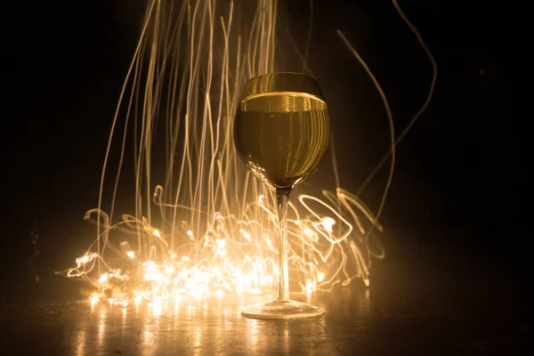背景に美しいトーンのライトと木製のテーブルの上のワインのゴブレット 暗い背景にワインのグラス 選択的フォーカス クラブドリンクのコンセプト — ストック写真