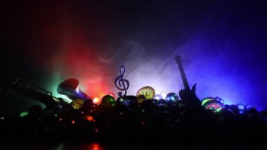 Müzik konsepti. Müzikal sembol, anahtarsız paslanmaz çelik minyatür sisli arka planda renkli bir ışık. Loş ışıkta müzik aletleri. Seçici odak