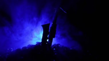 Müzik konsepti. Saksafon caz enstrümanı. Alto altın saksafon minyatürü, sisli arka planda renkli ışık. Loş ışıkta müzik aletleri. Seçici odak