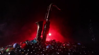 Müzik konsepti. Saksafon caz enstrümanı. Alto altın saksafon minyatürü, sisli arka planda renkli ışık. Loş ışıkta müzik aletleri. Seçici odak