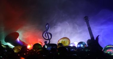 Müzik konsepti. Müzikal sembol, anahtarsız paslanmaz çelik minyatür sisli arka planda renkli bir ışık. Loş ışıkta müzik aletleri. Seçici odak