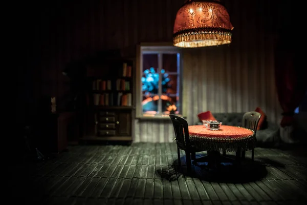 A realistic dollhouse living room with furniture and window at night. Stay home stay safe coronavirus concept. Selective focus.