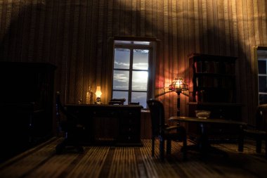 Geceleri mobilyası ve penceresi olan gerçekçi bir bebek evi oturma odası. El yapımı gerçekçi bebek eviyle sanat masası dekorasyonu. Seçici odak.