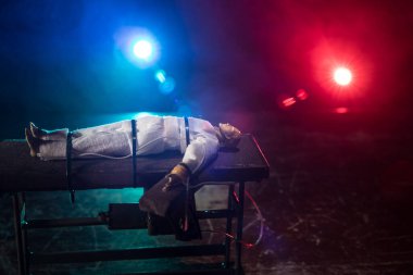 Zehirli iğne konsepti. Mahkûm zehirli iğneyle öldürülerek kelepçelenmiş. Işıklı ve koyu renk ölçekli yaratıcı sanat dekorasyonu.