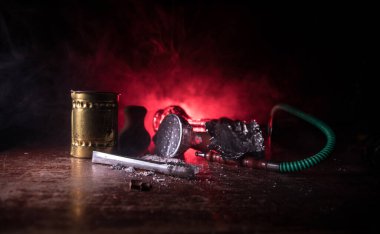 Shisha konsepti. Masada shisha hazırlıyorum. Ahşap masada kullanılmış shisha kasesi. Işıklı karanlık bir atmosfer. Seçici odak.