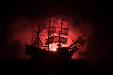 Geceleri korsan gemisinin siyah silueti. Gece sahnesinde, gizemli ışıkla denizde hayalet korsan gemisi görüldü. Seçici odak