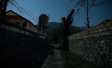 Gece sessiz köyde dolunay var. Ay ışığı altındaki dağ köyünün güzel gece manzarası. Azerbaycan doğası. Uzun pozlu çekim