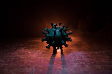 Coronavirus 2019-nCov romanı Coronavirus konsepti. Büyük Corona virüsü minyatür maketi ahşap masa üzerinde sis ve arka ışık ile. Yaratıcı sanat dekorasyonu. Seçici odak.
