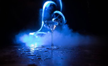 İçki, kırık cam konsepti. Ahşap masada kırık bardaklar, sisli, koyu tonlu arka plan. Seçici odak