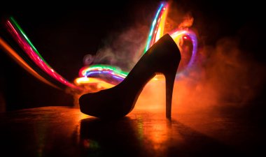 Sanat dekorasyonu. Karanlıkta topuklu kadın ayakkabılarının silueti. Kadın gücü ya da kadın egemenliği kavramı. Seçici odak