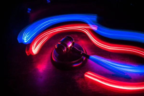 Hukuk, adalet kavramı. Yaratıcı çizim masası süslemesi hakimin tokmağı ile sisli arka planda renkli ışık ile. Seçici odak