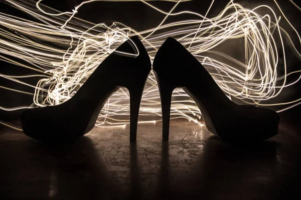 Sanat dekorasyonu. Karanlıkta topuklu kadın ayakkabılarının silueti. Kadın gücü ya da kadın egemenliği kavramı. Seçici odak