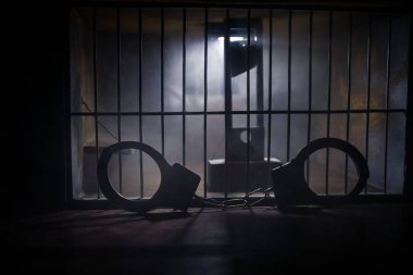 Uygulama kavramı. Eski hapishanede idam cezası giyotini minyatürü. Eski hapishane parmaklıkları hücre kilidi. Yaratıcı sanat dekorasyonu. Karanlıkta Giyotin ölçeği modelinin korkunç görünümü