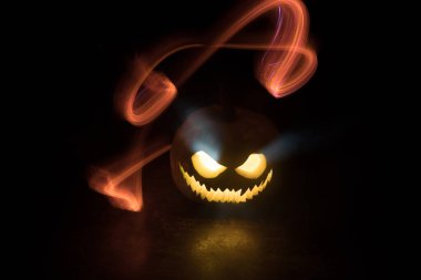 Cadılar Bayramı balkabağı gülüşü ve parti gecesi için korkunç gözler. Siyah arka planda parlayan gözleri olan korkunç Cadılar Bayramı balkabağı manzarasını kapat. Seçici odak