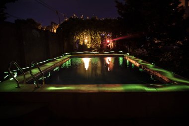 Gece havuzu, tatil geçmişi. Renkli ışık süslemesi. Dondurucu Işık
