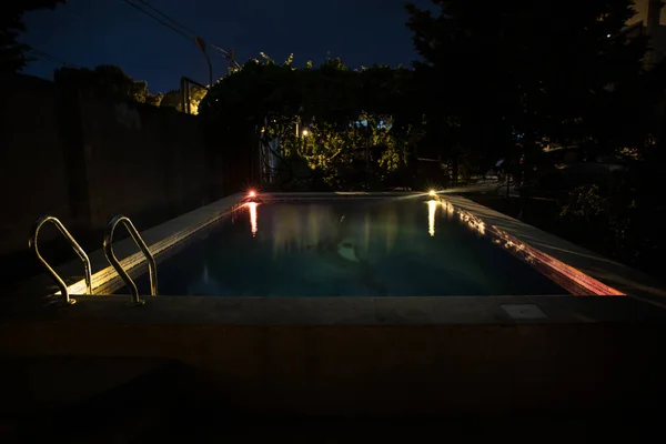 Pool at night - vacation background. Colorful light decoration. Freezelight