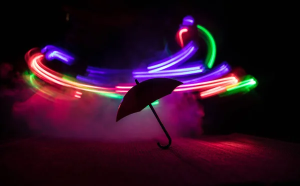 Silueta Paraguas Miniatura Sobre Mesa Con Fondo Nebuloso Tonificado Oscuro —  Fotos de Stock