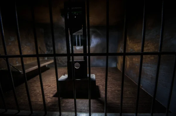 执行概念 旧监狱里的死刑缩影 老监狱的铁窗锁创意艺术装饰 黑暗中断头台天平模型的恐怖视角 — 图库照片