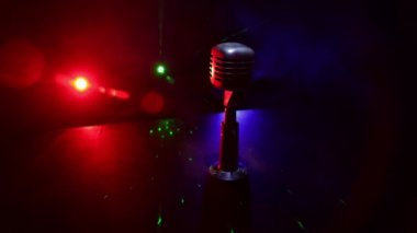 Mikrofonun karanlık odadaki arka lambalı görüntüsü. Seçici odak