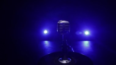 Mikrofonun karanlık odadaki arka lambalı görüntüsü. Seçici odak