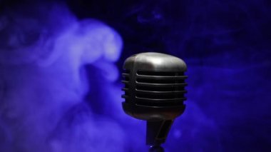 Mikrofonun karanlık odadaki arka lambalı görüntüsü. Seçici odak