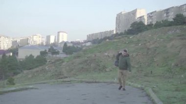 Boş şehir caddesinde yürüyen yalnız bir adam. Kapüşonlu genç adam dışarıda.