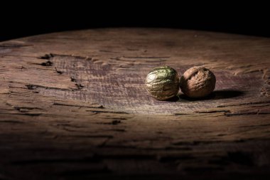 Fındık yemeği konsepti. Ceviz çekirdekleri ve eski ahşap masadaki cevizlerle dolu bir hayat. Yaratıcı masa dekorasyonu. - Yakın çekim. Seçici odak