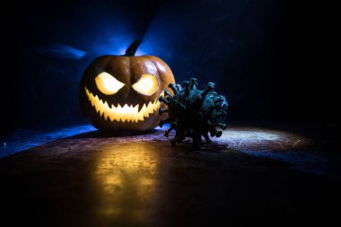 Corona virüsü küresel pandemik konsepti sırasında Cadılar Bayramı. Karanlıkta parlayan balkabakları ve Covid romanı tematik ürkütücü süslemelerle. Cadılar Bayramı balkabağı sisli arka planda. Seçici odak