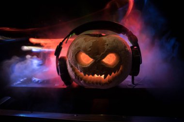 Cadılar Bayramı balkabağı DJ masasında, kulaklıklar koyu arkaplanda ve fotokopi alanı var. Mutlu Cadılar Bayramı Festivali dekorasyonları ve müzik konsepti