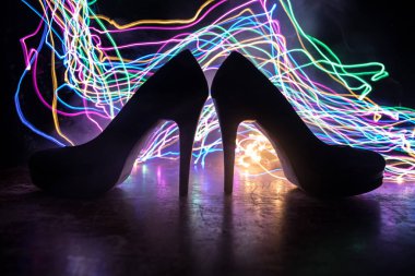 Sanat dekorasyonu. Karanlıkta topuklu kadın ayakkabılarının silueti. Kadın gücü ya da kadın egemenliği kavramı. Seçici odak