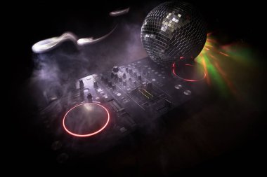 Kulüp müzik konsepti. DJ konsol masası renkli ışıkla karanlıkta DJ karıştırma masası. Karışık ekipman eğlence DJ istasyonu. Seçici odak